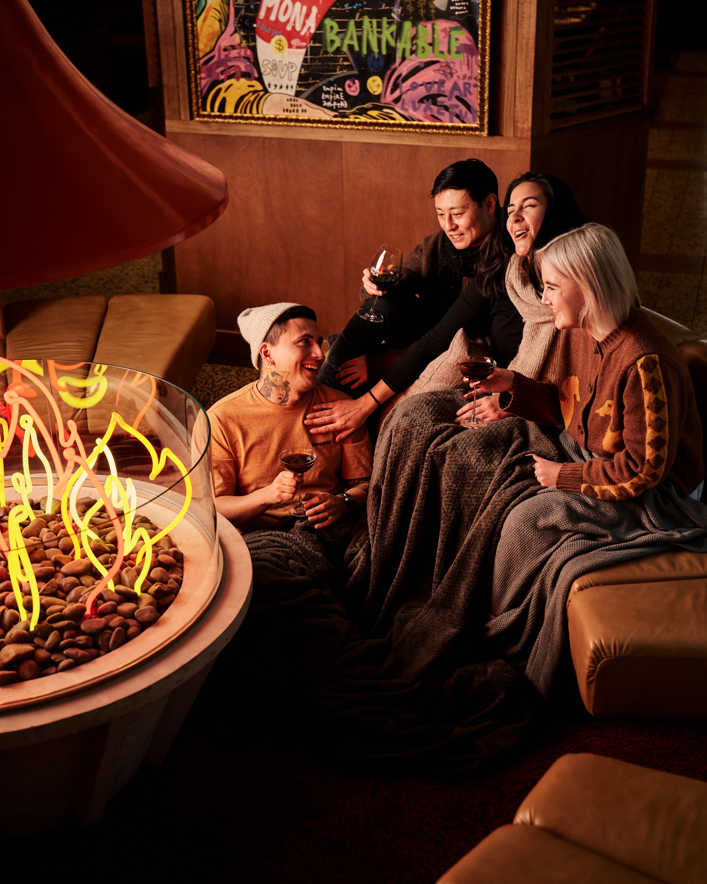 Guests talking around a lit fire feature in the Ovolo South Yarra lounge